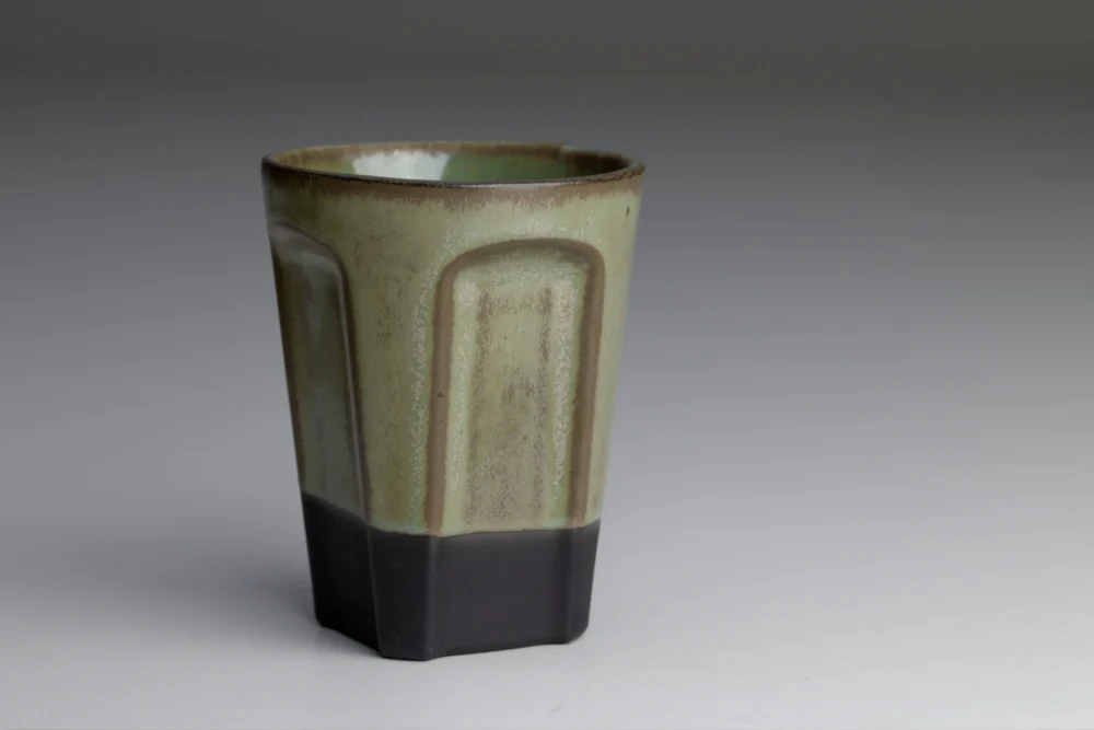 Groene keramische beker met zwarte basis