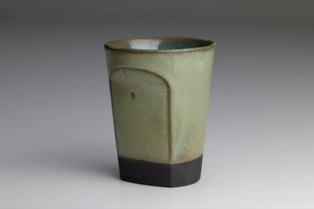 Groene keramische beker op grijze achtergrond