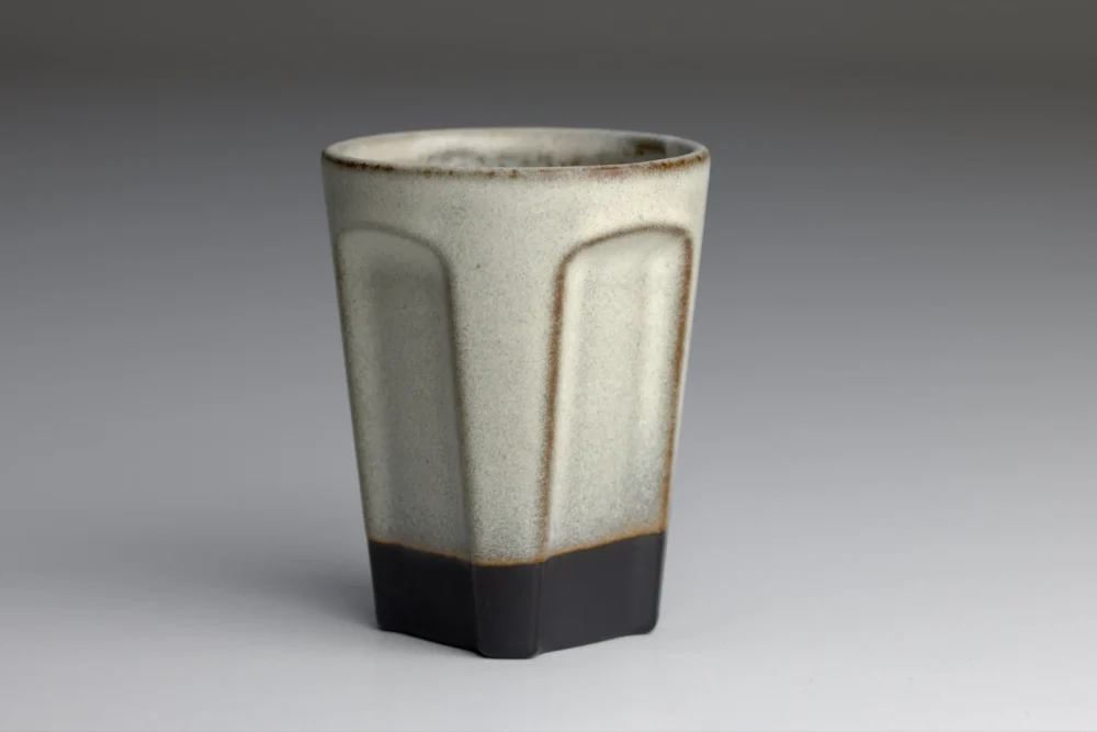 Grijze keramische beker met zwart voetstuk