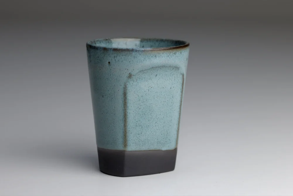 Blauwe keramische beker met donkere basis