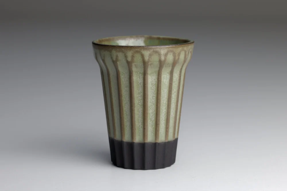 Gegroefde keramische beker met groene en zwarte kleuren